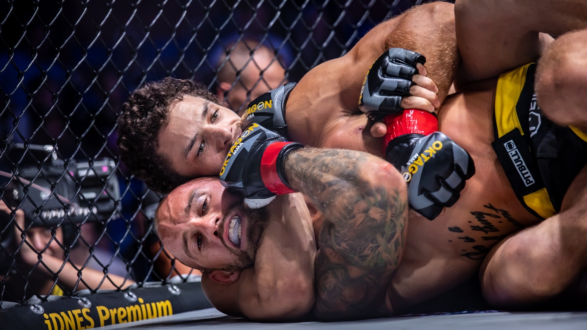 Premium Photo  Male mma fighter performs painful choke hold to his  opponent in a cage in gym.